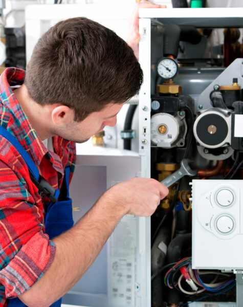 Technician servicing heating boiler Technician servicing the gas boiler for hot water and heating